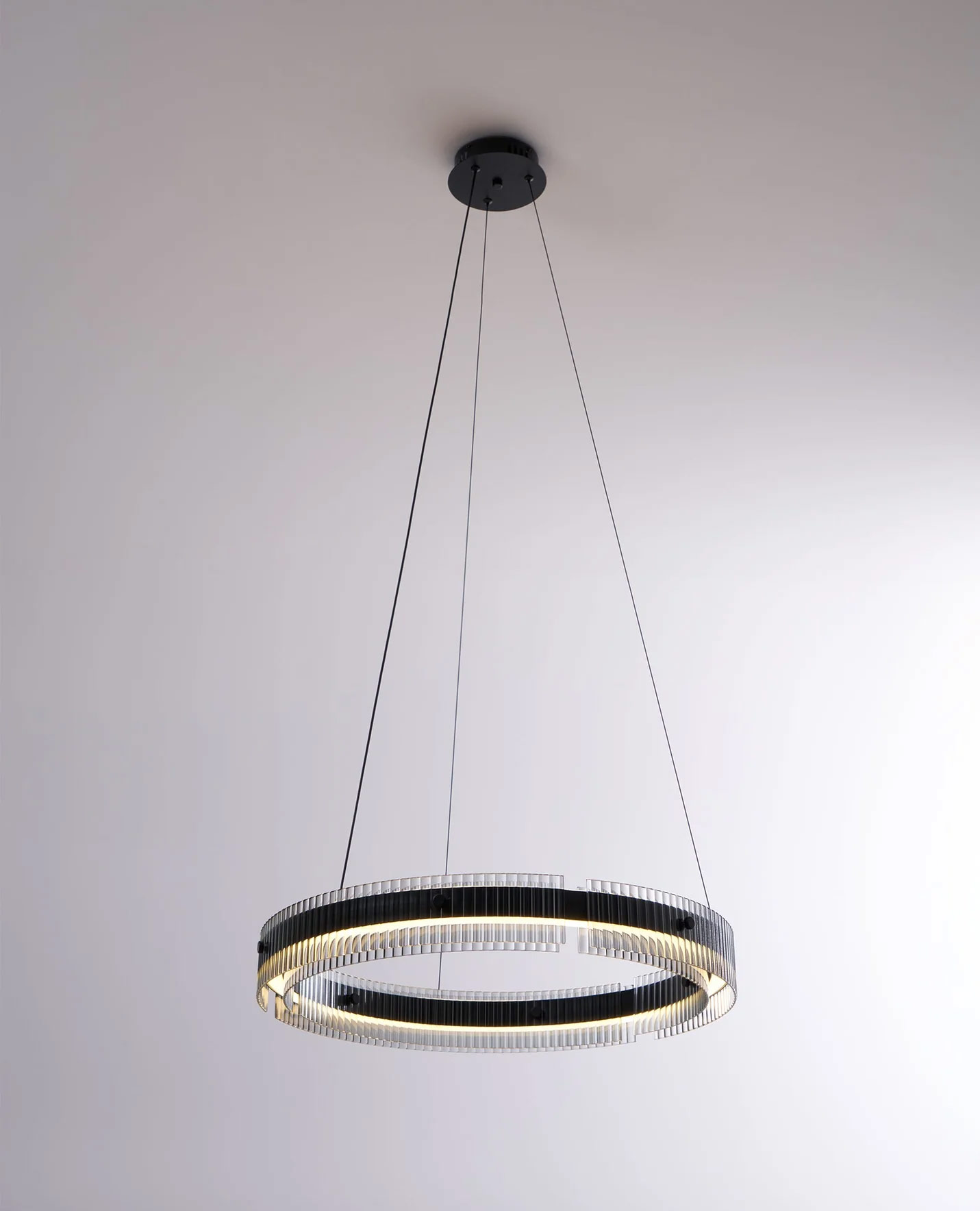 Black and clear ribbed glass orbital pendant light with integrated LED, suspended circular design in minimalist modern style