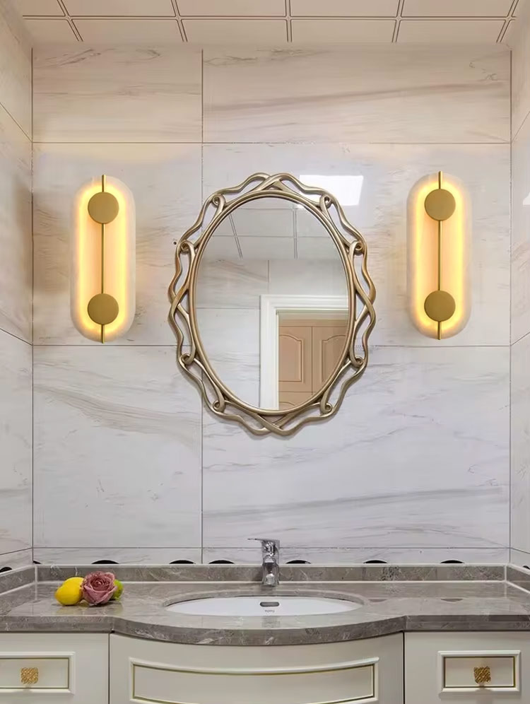 Pair of oval wall lights mounted beside bathroom mirror