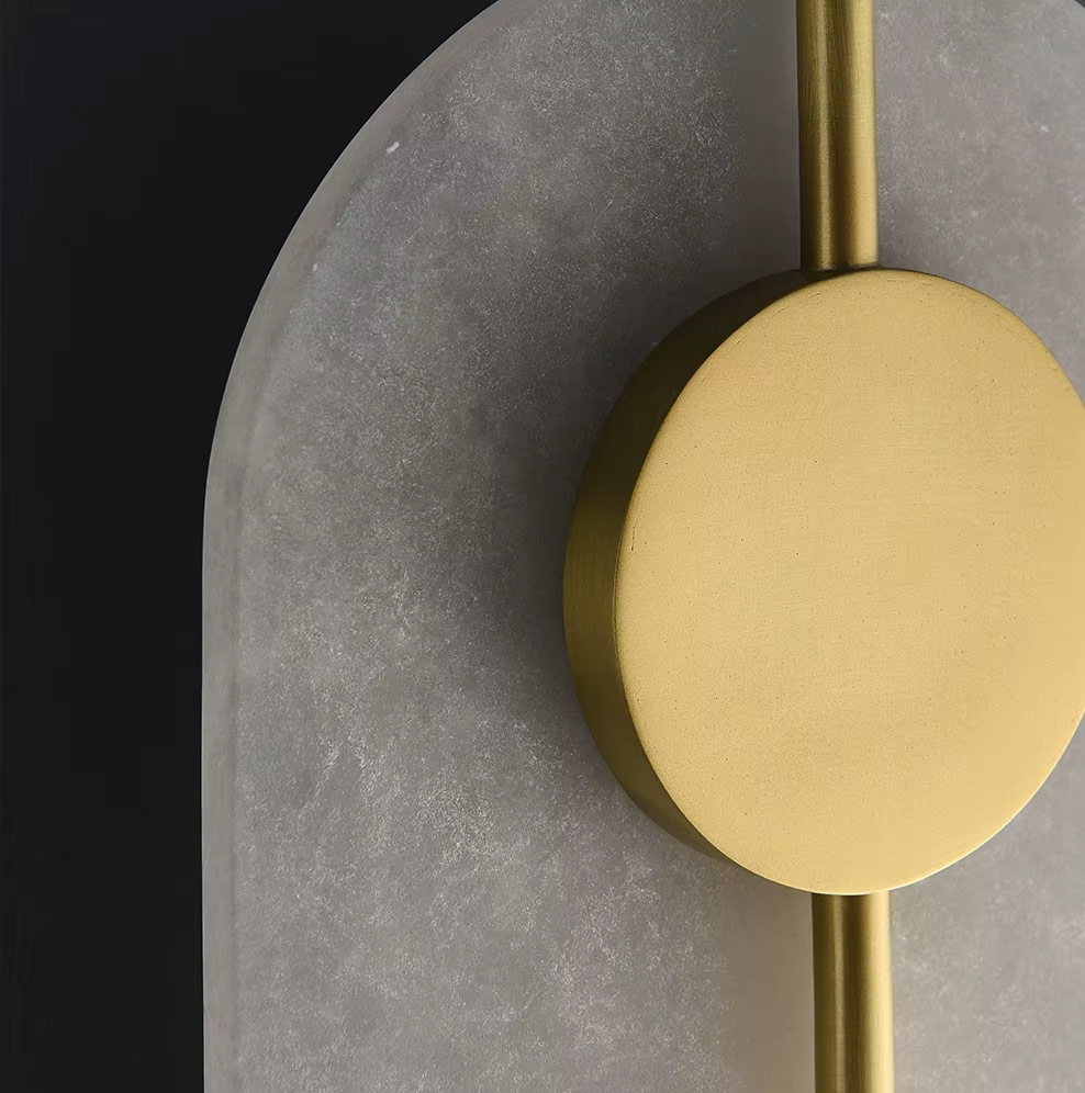 Textured glass panel and brass disc detail of wall light