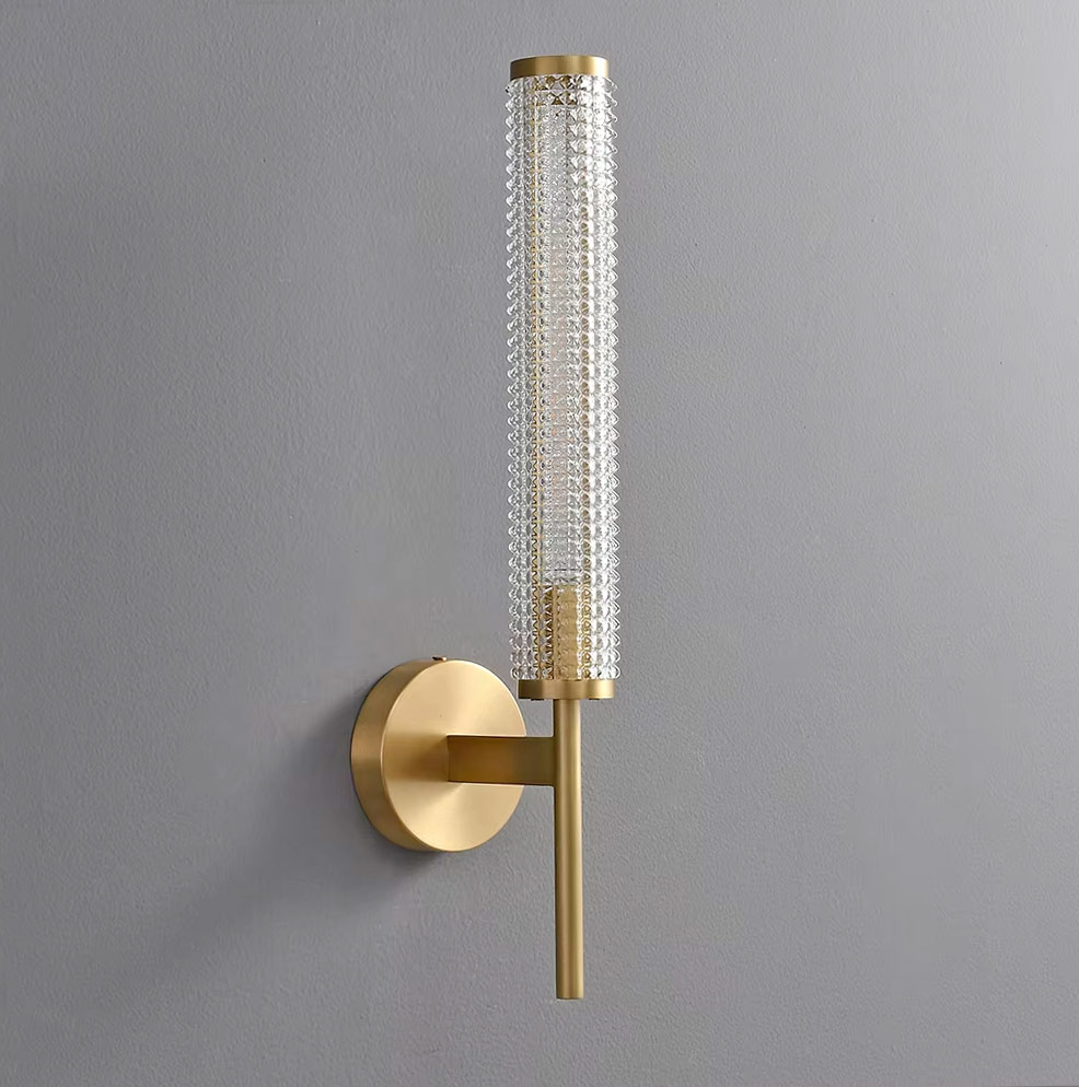 Angled view of brass and glass wall-mounted light