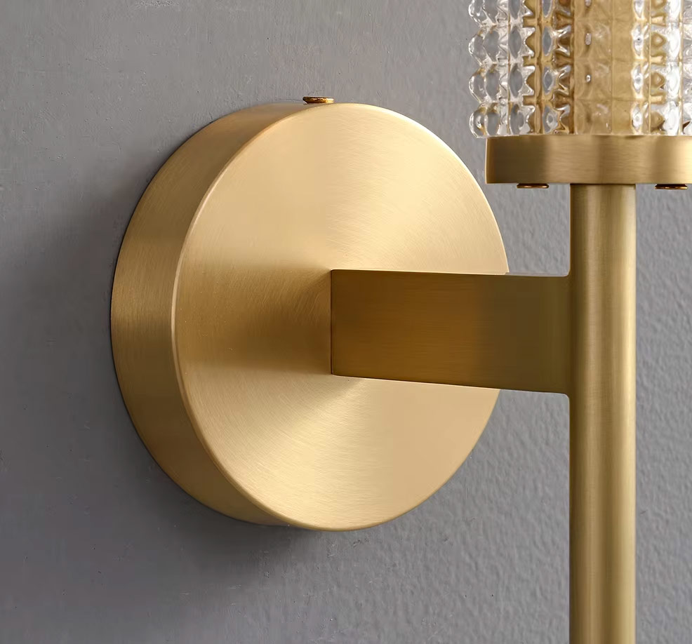 Round brass wall plate and arm detail of wall light