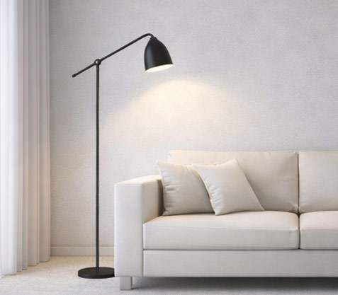Modern floor lamp placed beside a sofa with extended arm reaching over seating area, demonstrating proper placement and light coverage without obstructing walkways.